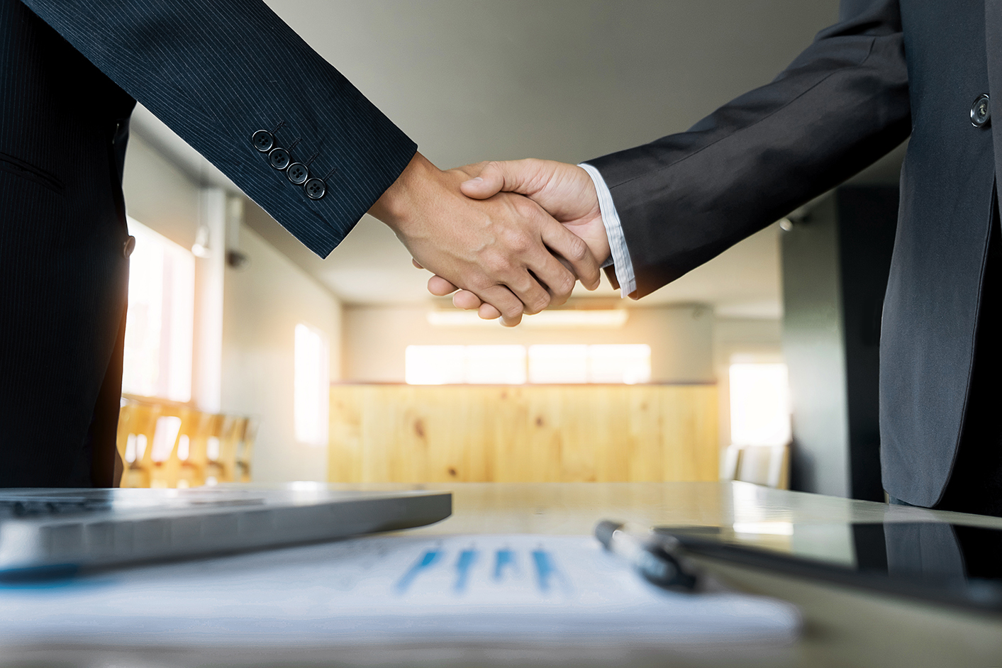 Two confident business man shaking hands during a meeting in the
